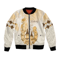 Beige unisex bomber jacket with gold front crest, full zipper, black ribbed trim