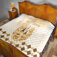 Quilt on bed featuring diamond quilting and gold Kentucky horse emblem, beige accent border