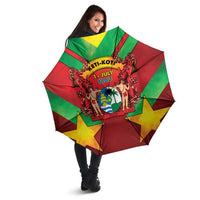 Open red, green, and yellow star-pattern umbrella with central crest graphic