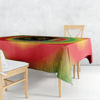Juneteenth Freedom Day tablecloth in rainbow tie-dye with green draped corner over table