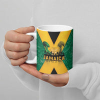 Green ceramic Jamaica mug in hands with black and gold X graphic and handle