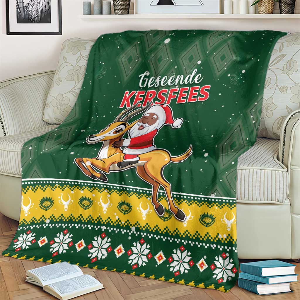 Green throw blanket showing Santa riding springbok under diamond pattern with festive hem