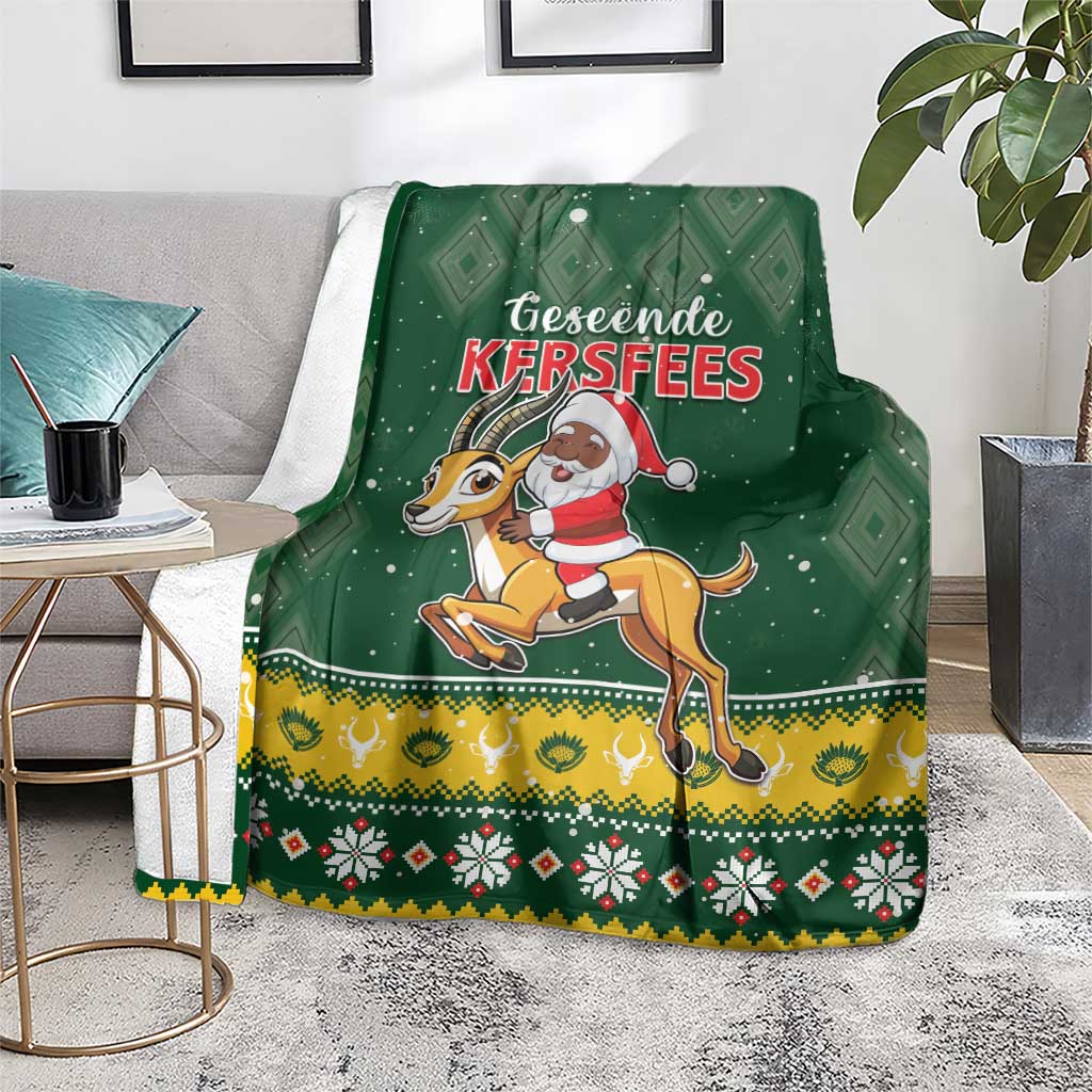 Green Christmas blanket over couch, Santa-on-springbok graphic with yellow and red trim
