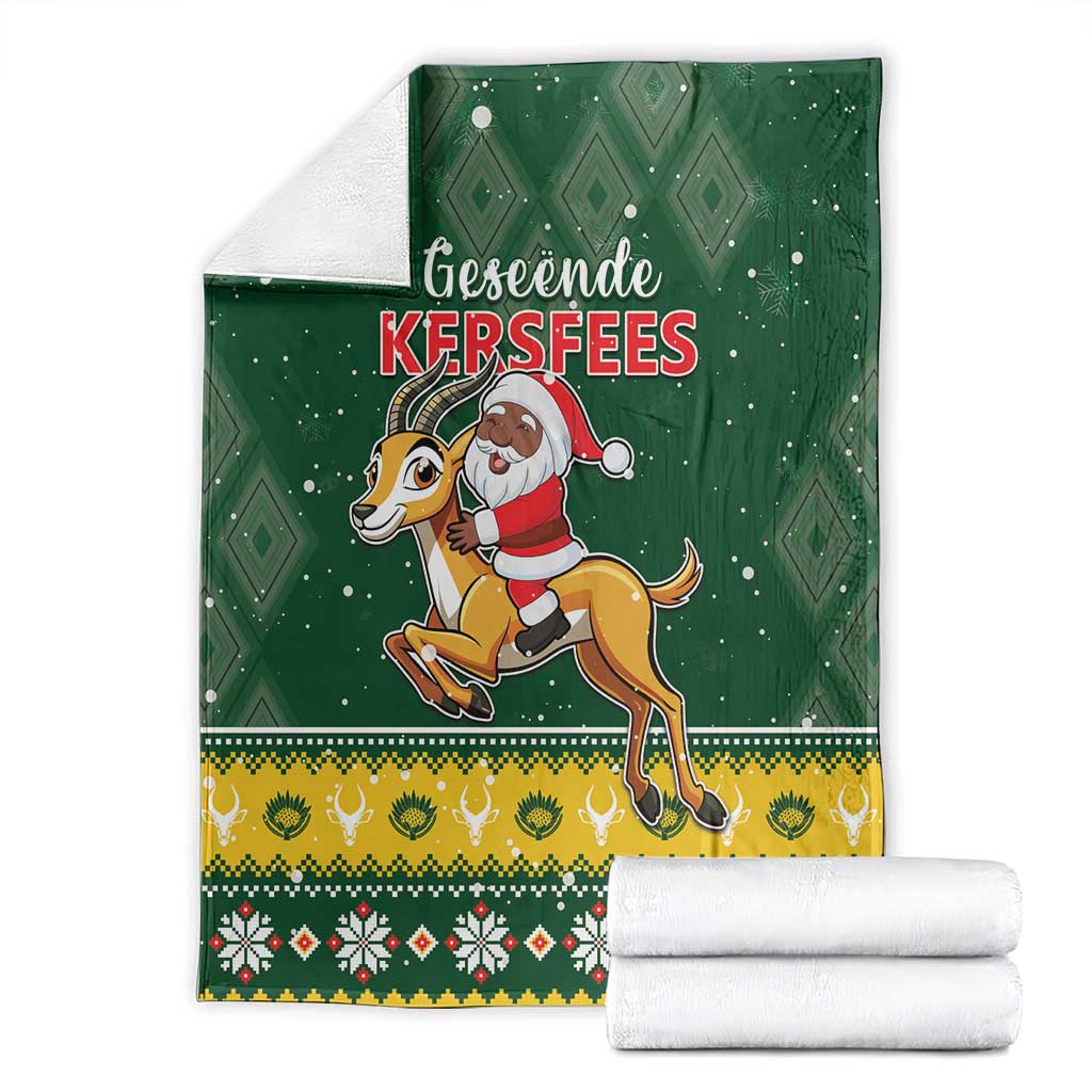 Green Christmas blanket folded with Santa riding springbok, diamond print and holiday border
