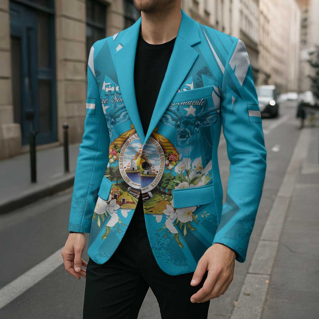 Unisex teal-blue blazer with printed crest center, floral accents, and light-blue cuff tabs.