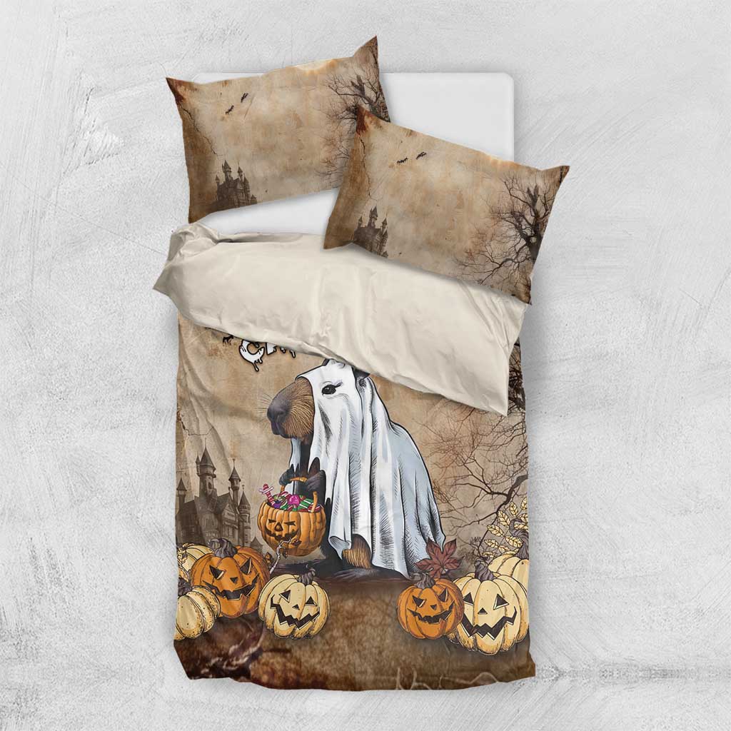 Halloween bedding set laid flat: beige-brown duvet and two pillowcases with capybara ghost and pumpkins