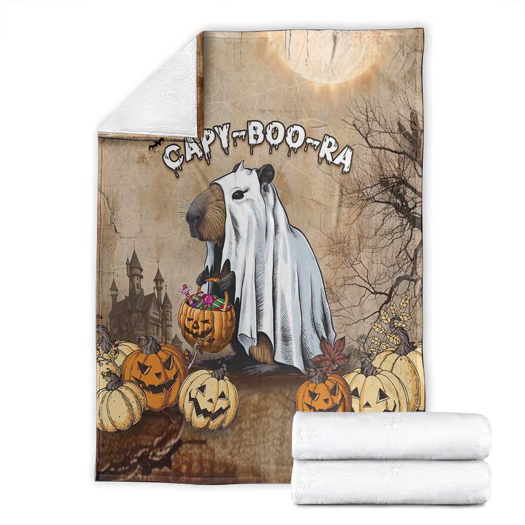 Beige Halloween blanket with capybara ghost artwork and folded white towels