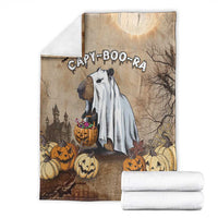 Beige Halloween blanket with capybara ghost artwork and folded white towels