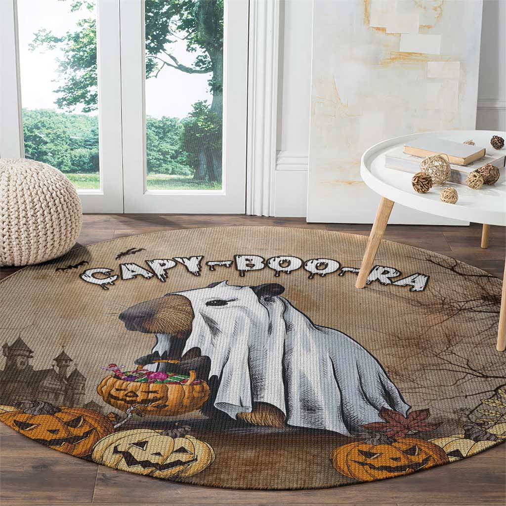 Beige round Halloween rug with capybara and jack-o’-lanterns, on wooden floor