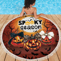 Orange round Halloween beach blanket with white fringe, "Spooky season" pumpkin scene