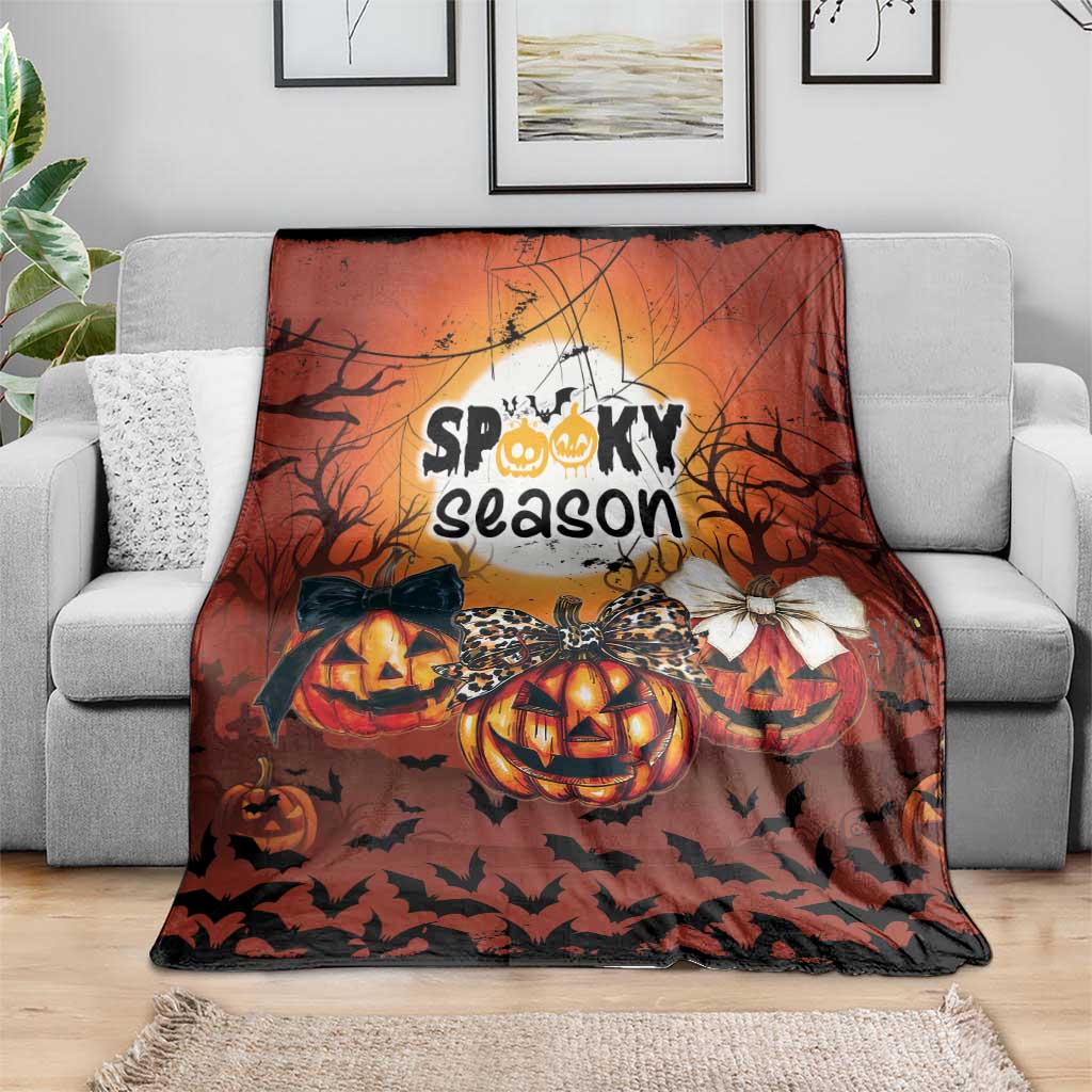 Halloween blanket with “Spooky season” design, jack-o’-lantern pumpkins, bats, and bows