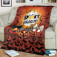 Orange Halloween blanket draped on a sofa, “Spooky season” print with pumpkins and bats