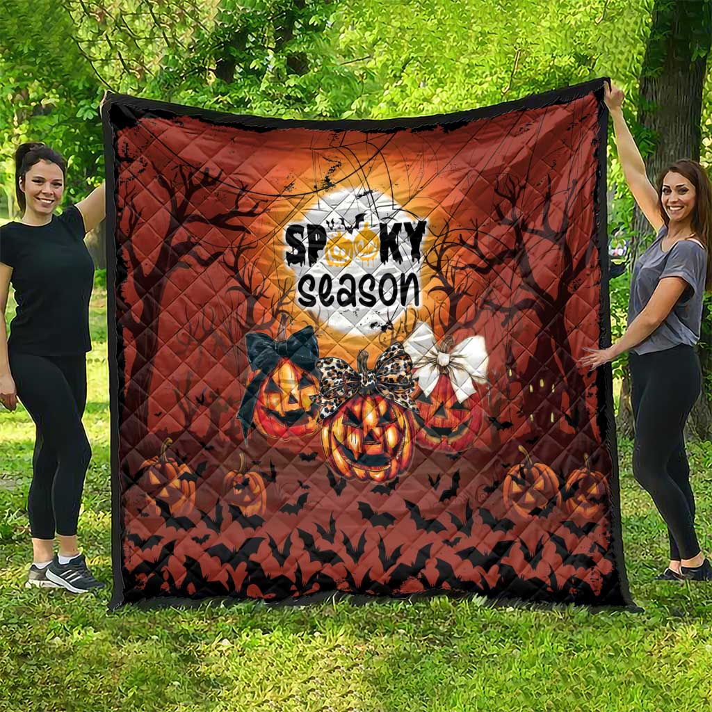 Spooky season Halloween quilt in orange and black with moon graphic, pumpkins, and bats