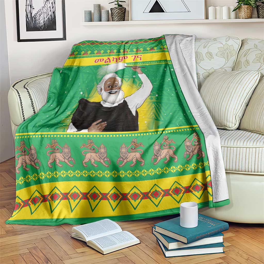 Green Christmas blanket with saint figure and festive border patterns, draped on a couch