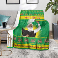 Green Christmas blanket showing saint figure, festive bands, and repeating animal prints