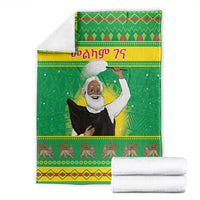 Green Christmas blanket with saint portrait, patterned top border, and striped bottom trim
