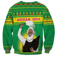Unisex green Christmas sweatshirt with MELKAM GENA text and raised-arm saint graphic