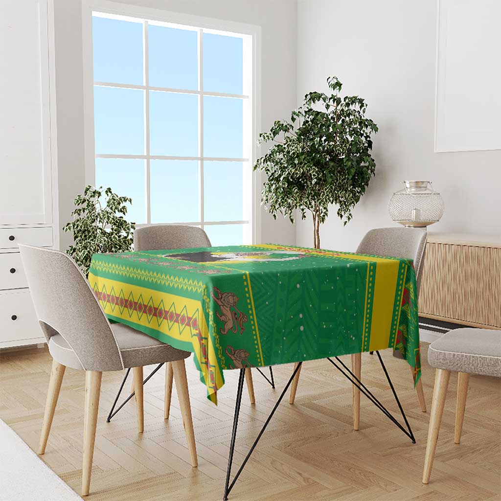 Green Christmas tablecloth draped over dining table with patterned edge and motifs