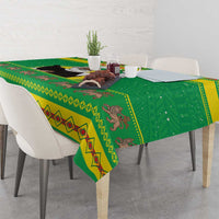 Green Christmas tablecloth with illustrated motifs and bordered pattern on tabletop