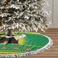 Green Christmas tree skirt with white fringe edge and central printed figure under tree