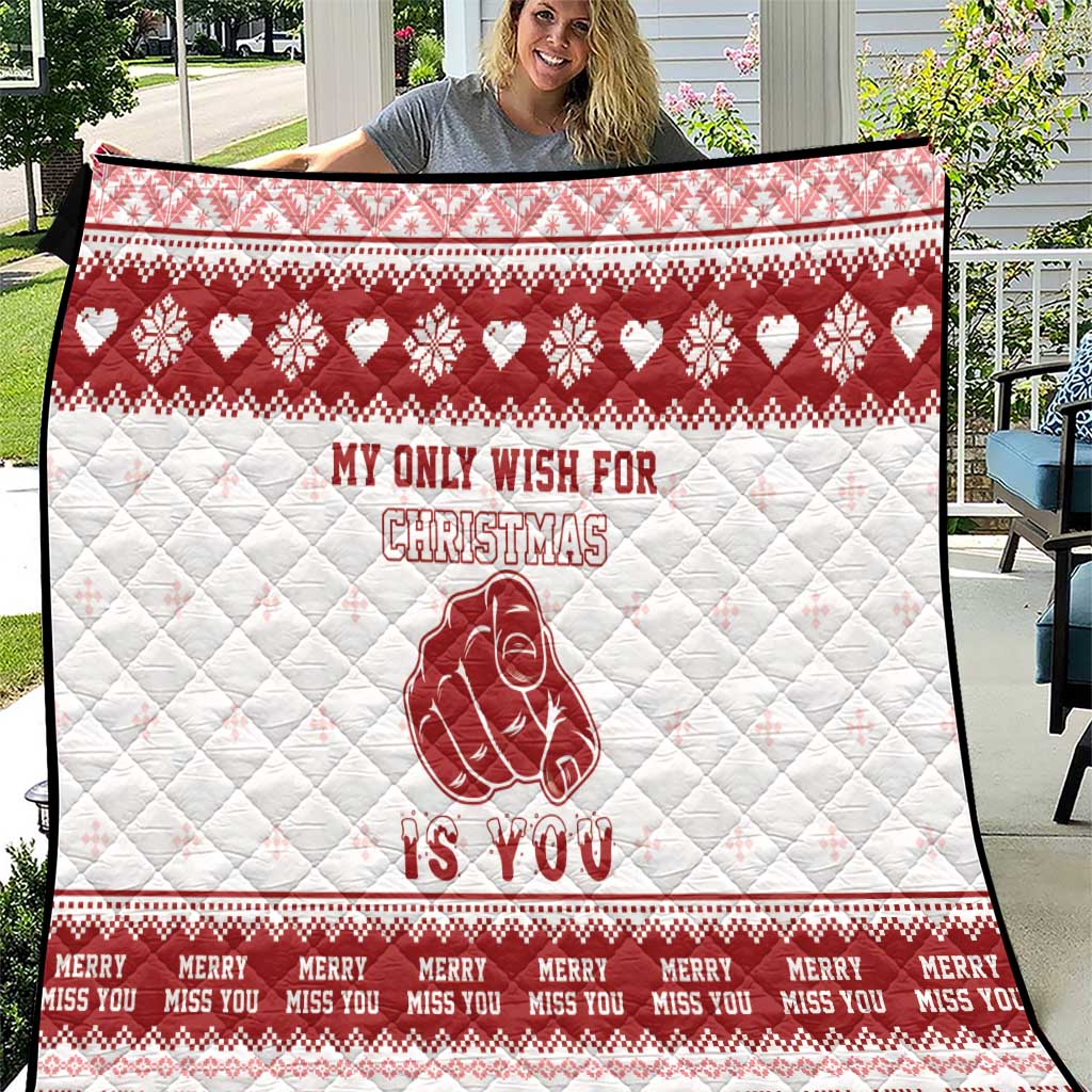 Red and white quilt blanket with quilted diamonds, holiday hearts, and a hooded figure