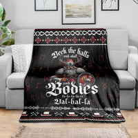 Black Christmas blanket draped over a sofa, Viking skull graphic and festive knit border
