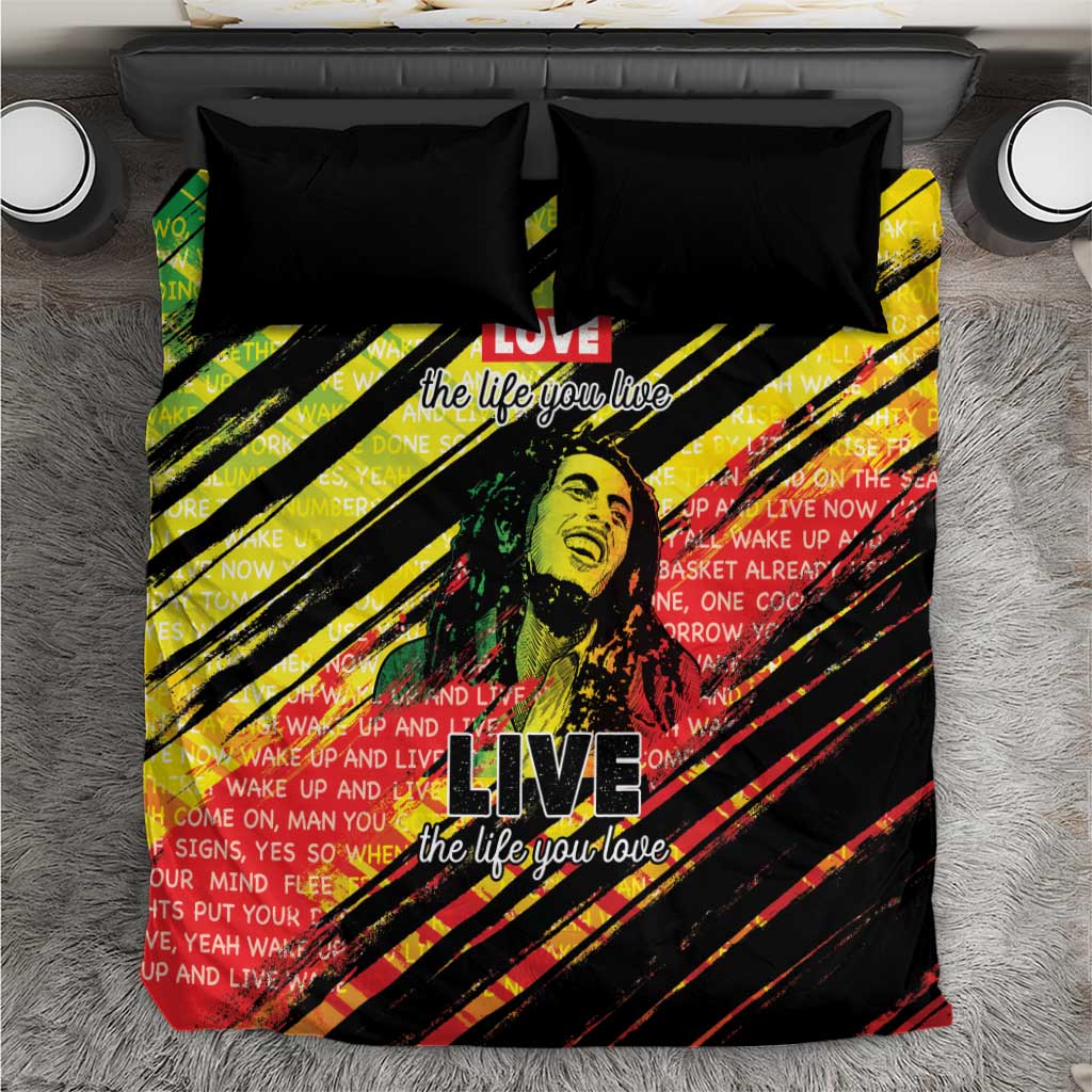 Black bedding set with yellow, red, green diagonal stripes and bold “LIVE” graphic on duvet