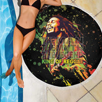 Black round beach blanket with white fringed edge, reggae text and portrait graphic