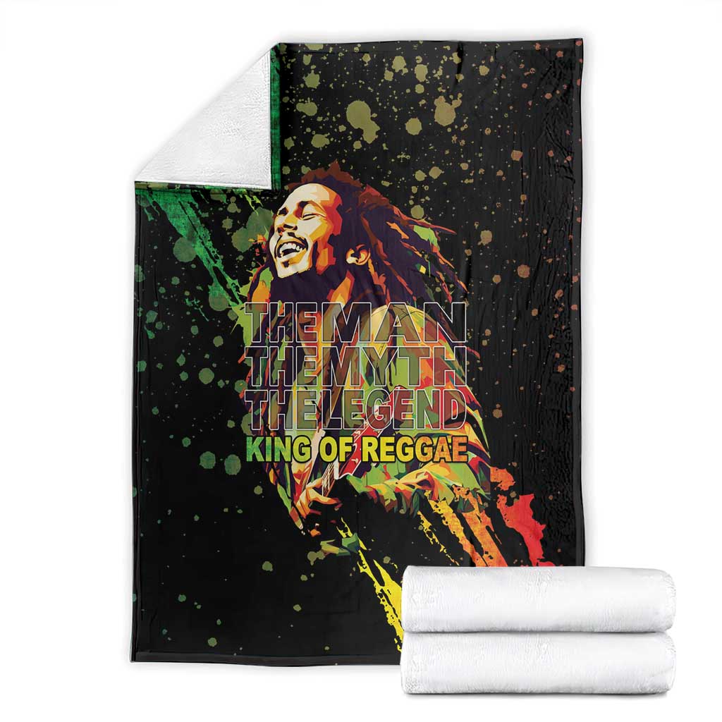 Black reggae graphic blanket with musician portrait; folded with white stack of towels