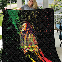 Black quilted throw with colorful reggae king portrait graphic and diamond stitch pattern.