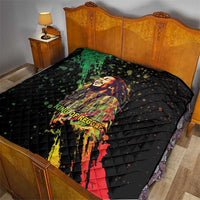 Black quilted bed throw blanket with colorful reggae king portrait graphic and diamond stitching.