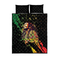 Black quilt bed set with quilted pillow shams and central reggae poster-style print