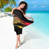 Black sarong with colorful reggae performer print and paint-splash accents, draped