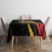 Black tablecloth on dining table with multicolor paint stripe design and speckles