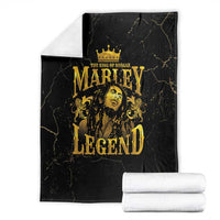 Black fleece blanket with gold Marley Legend crowned portrait, stacked with white rolls