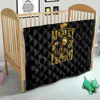 Black quilt with gold “MARLEY LEGEND” graphic laid on a baby bed