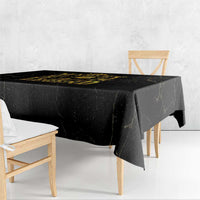 Black tablecloth with gold Marley “Legend” graphic, hanging over side of table