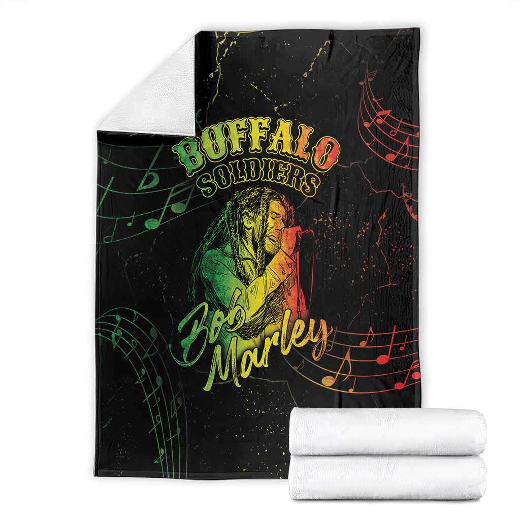 Folded black Buffalo Soldiers and Bob Marley graphic blanket with rolled white towels