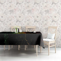 Black printed tablecloth with red and green splatter lines on long dining table