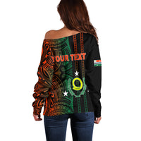 Off-shoulder sweater in black with green and orange tribal print, YOUR TEXT on back
