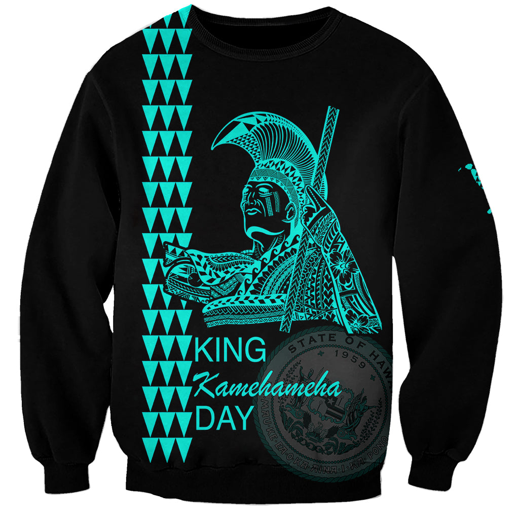 Unisex black sweatshirt with teal King Kamehameha Day graphic and text on front