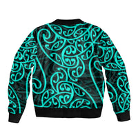 Bomber jacket with turquoise Maori-style swirling pattern, back view, ribbed hem and cuffs