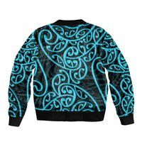 Bomber jacket back view with black base and light blue swirling Maori-style pattern