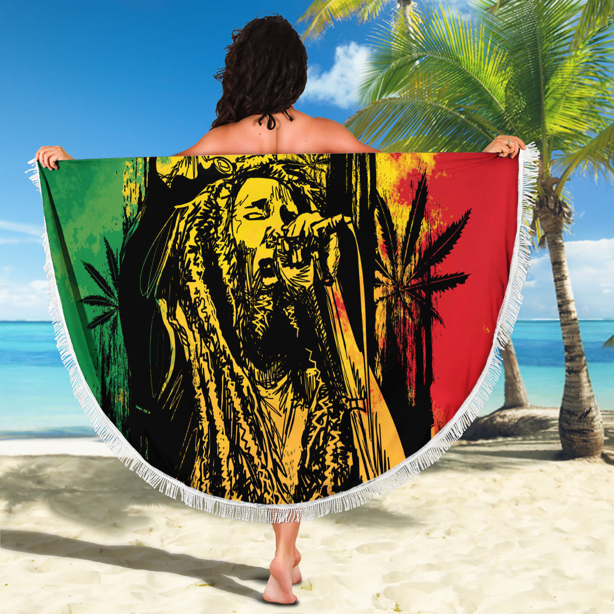 Round fringed beach blanket with reggae grunge "YOUR TEXT" graphic held up on a sunny beach.