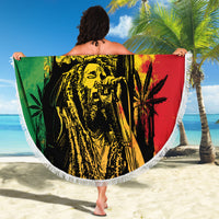 Round fringed beach blanket with reggae grunge "YOUR TEXT" graphic held up on a sunny beach.