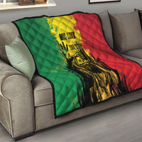 Quilt throw on sofa with green and red sides, yellow splatter center, and portrait graphic