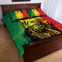 Quilt bed set on bed frame; green and red quilt with yellow center and black graphic