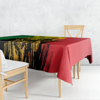 Rectangular tablecloth draped over table, green and red grunge brush graphic with yellow highlights