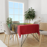 Tablecloth with red center and green/yellow/black grunge artwork covering dining table