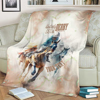 Beige horse racing anniversary blanket on couch with Kentucky Derby 151st crest and horses
